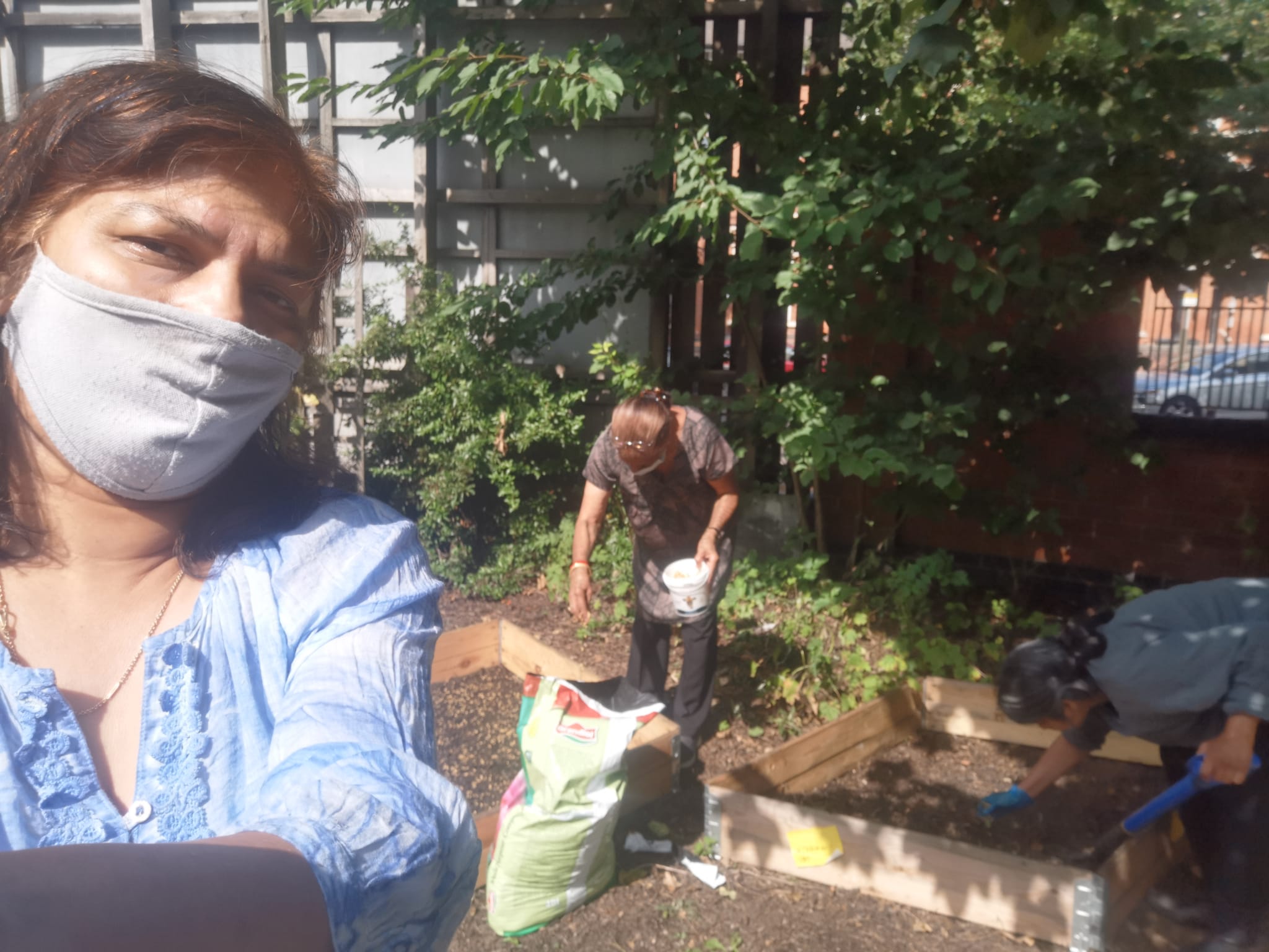 adding soil and seeds to raised beds